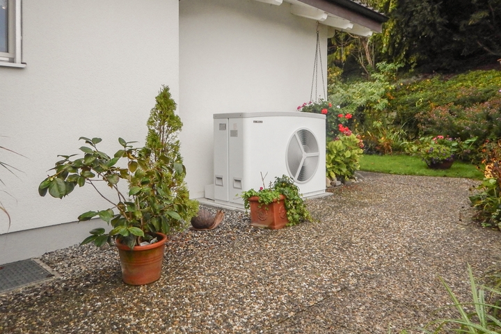 Wärmepumpe vor einem Einfamilienhaus.