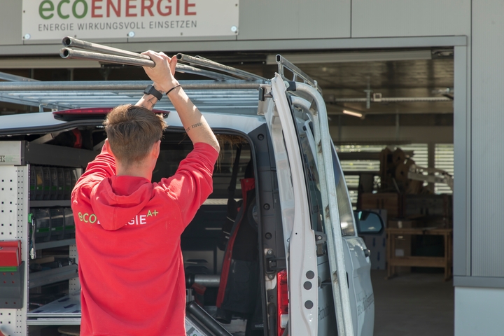 Ein Mitarbeiter der eco energie a plus ag macht sein Firmenfahrzeug für den Einsatz bereit.